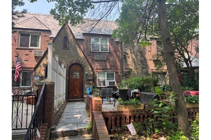 View of front of house featuring a high end roof, brick siding, and an outdoor living space