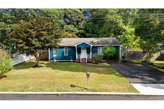 View of front of home with a shingled roof, a porch, and asphalt driveway