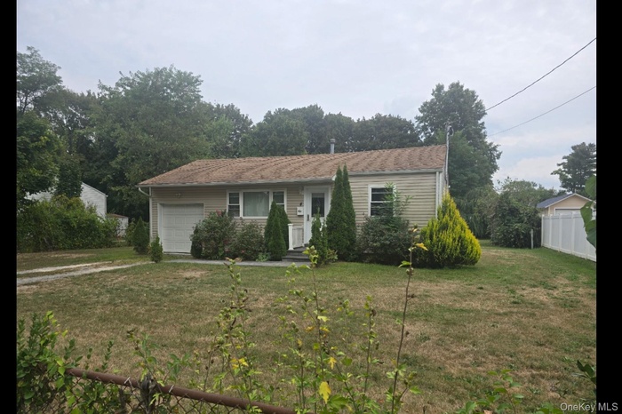 Ranch-style house with an attached garage and view of scattered trees