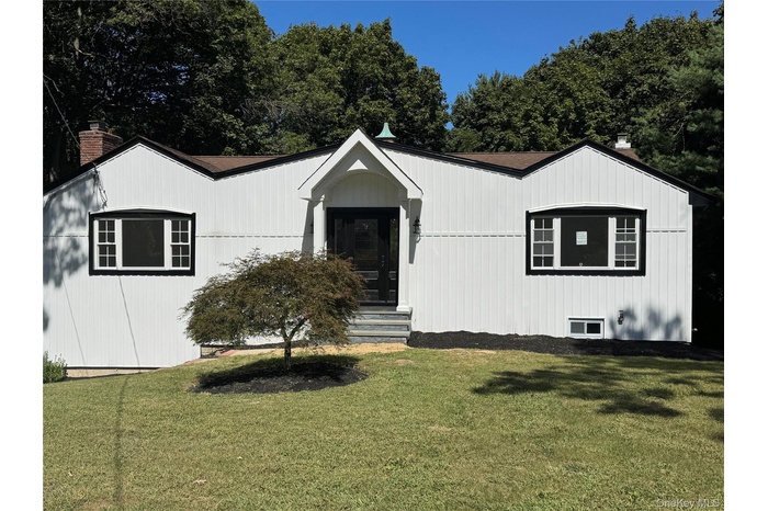 View of front of home with a front yard and a chimney