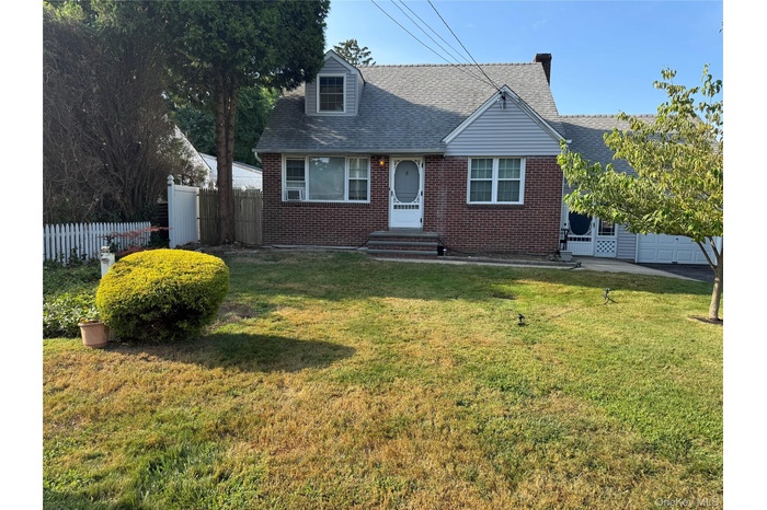 View of front of home with brick siding, roof with shingles, and an attached garage