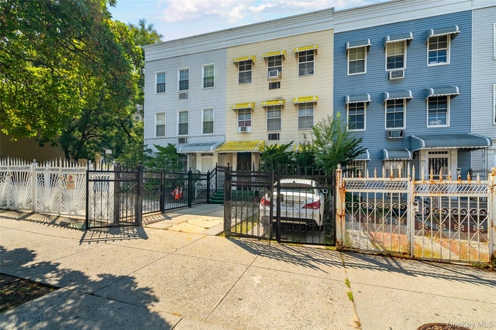 View of front facade with a fenced front yard and a gate
