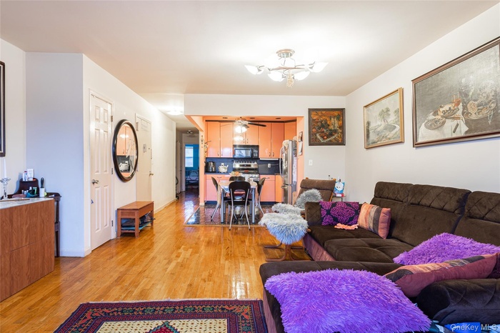 Living room with light wood-style flooring and a ceiling fan