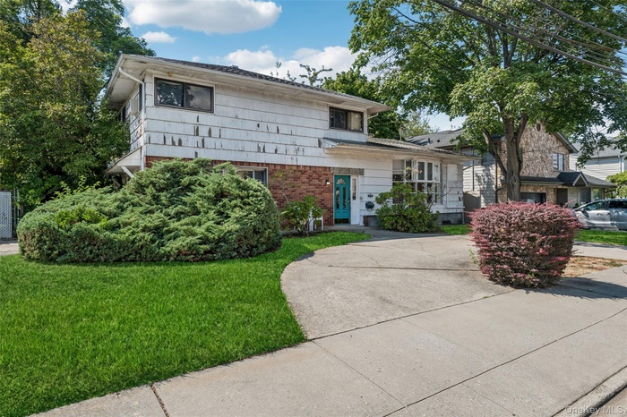 Split level home featuring brick siding and a front yard