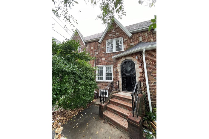 View of front of house with brick siding and roof with shingles