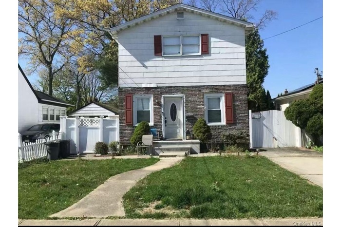 Colonial-style house with a gate and brick siding