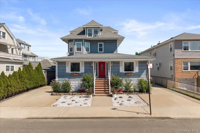 Traditional style home with a porch and a shingled roof