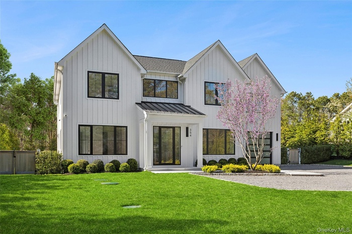 Modern inspired farmhouse featuring fence, a front lawn, a standing seam roof, and board and batten siding