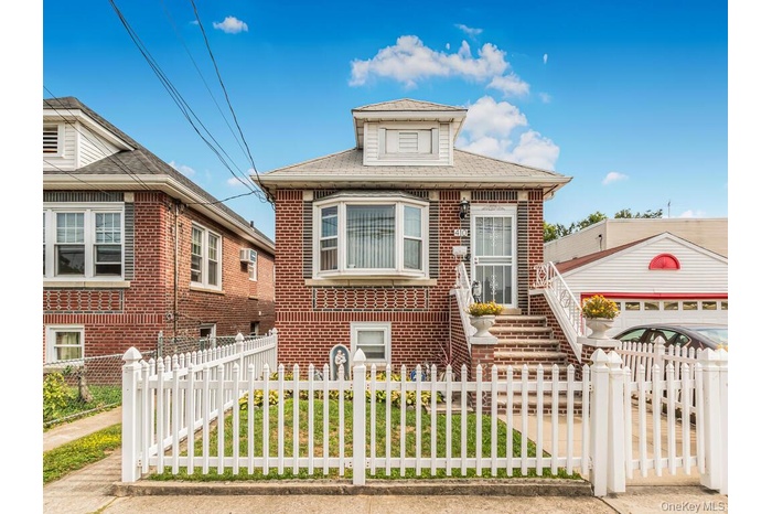View of front of house with a fenced front yard, brick siding, and a shingled roof