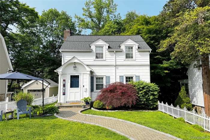 View of front facade with a chimney and a shingled roof