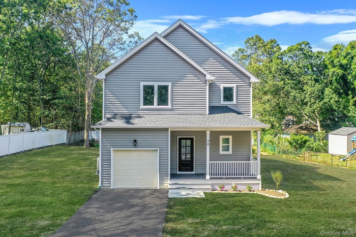 View of front facade with a porch, roof with shingles, an attached garage, and driveway