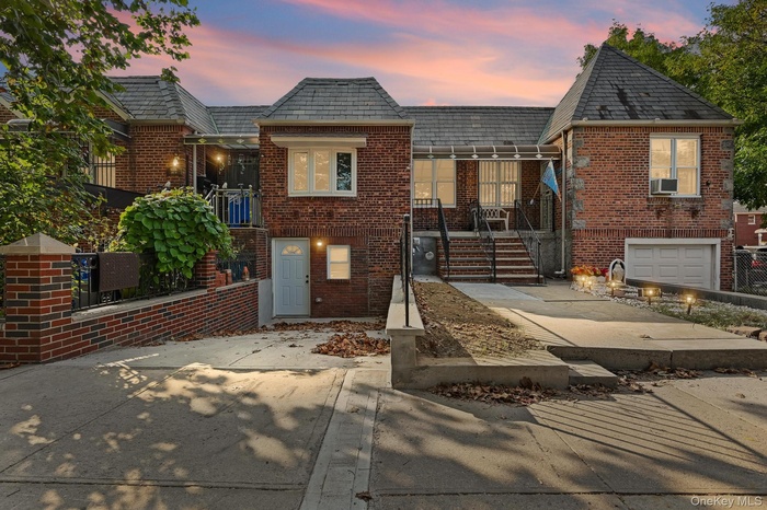 View of front of home featuring brick siding, concrete driveway, and stairway