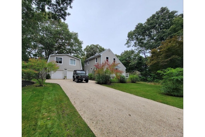 View of front of house featuring an attached garage, driveway, and a front lawn