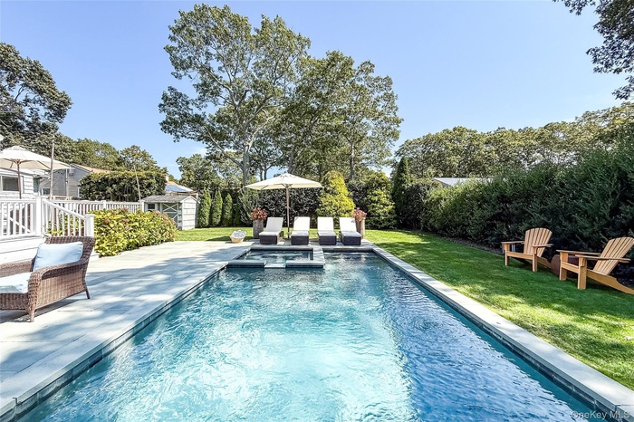 View of pool featuring a pool with connected hot tub, a shed, and a patio