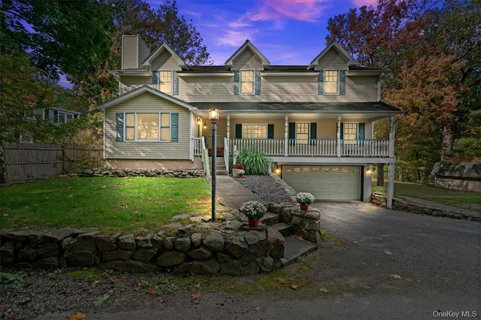 View of front facade featuring a yard, a porch, and a garage