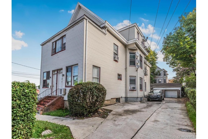 View of front of house with an outbuilding and a garage