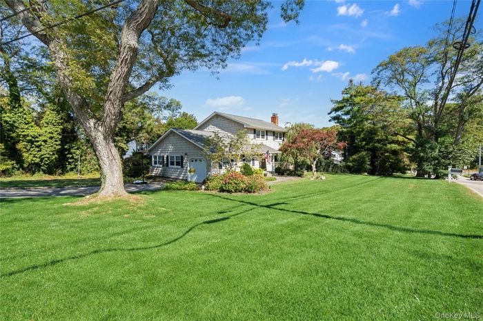 View of green lawn with view of wooded area