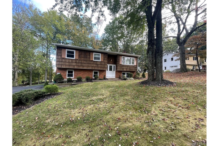Split foyer home featuring a front lawn and brick siding