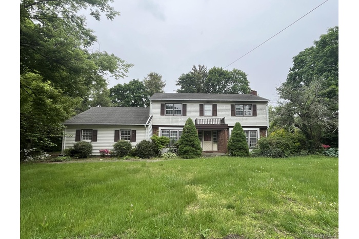 View of front facade with a chimney and a front lawn