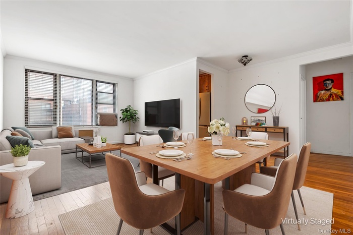 Dining area featuring light wood-type flooring and crown molding