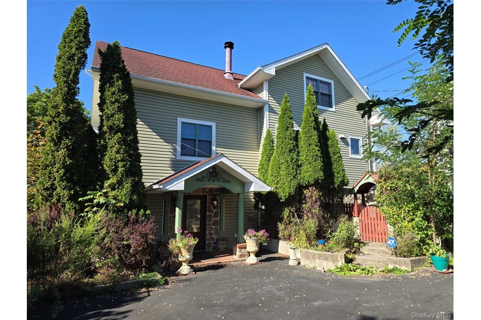 View of back of home with roof with shingles
