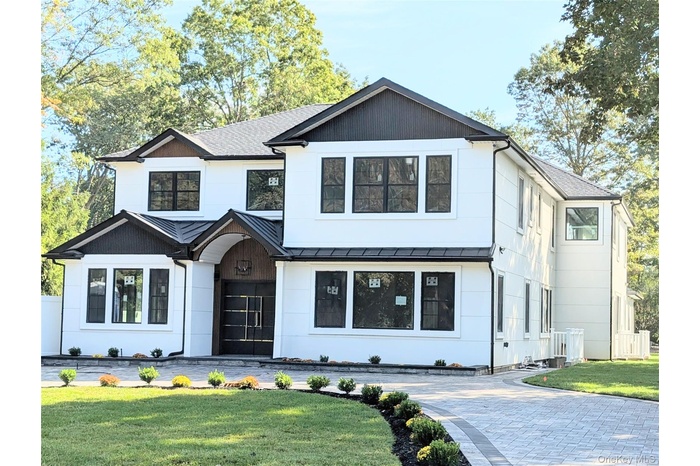 Modern inspired farmhouse with a standing seam roof, a metal roof, and a shingled roof