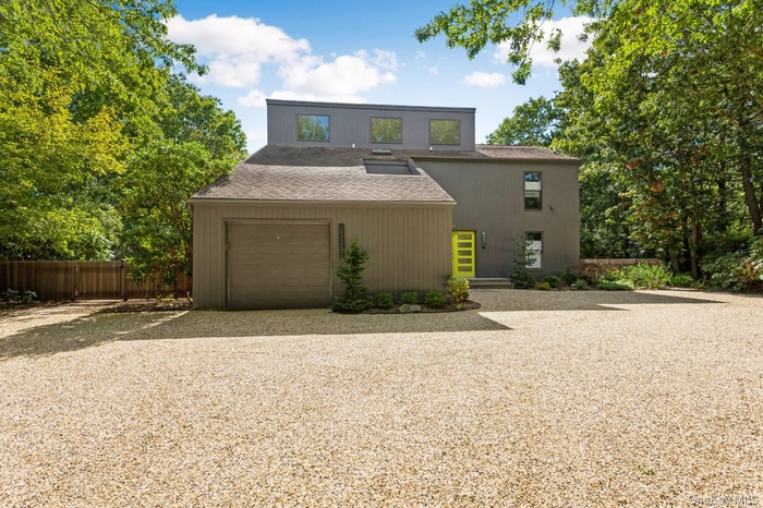 View of front of home featuring driveway, a garage, and a shingled roof