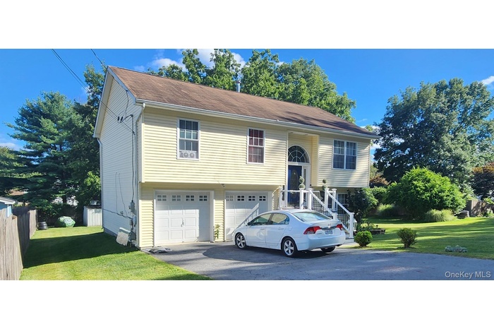 Split foyer home with driveway and a garage