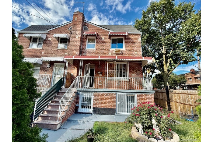 Back of house featuring brick siding, a porch, and a chimney