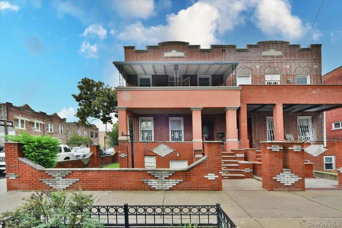 View of front of house featuring brick siding and a balcony