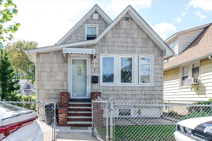 Bungalow-style home featuring a fenced front yard, a gate, and entry steps