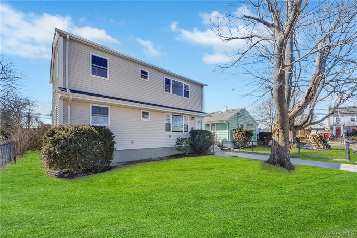 Back of property featuring a yard and fence