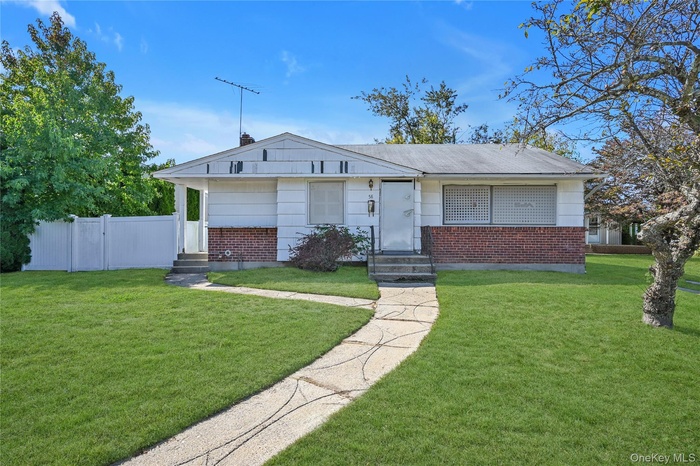View of front of property with entry steps, brick siding, and a chimney