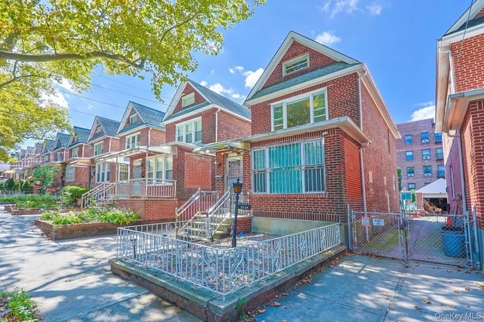 View of front facade with a gate, brick siding, and a residential view
