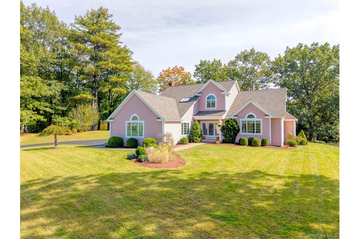 View of front facade with a front lawn and view of scattered trees