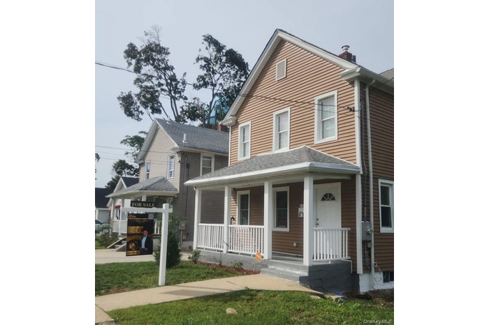 View of front of home with covered porch and roof with shingles