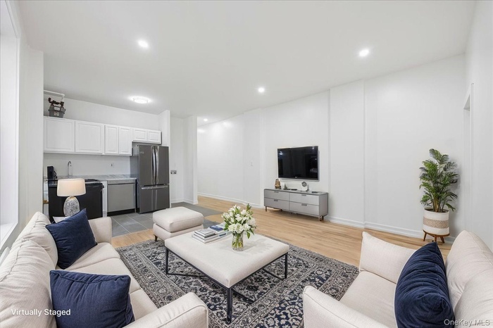 Living room with light wood-style floors and recessed lighting