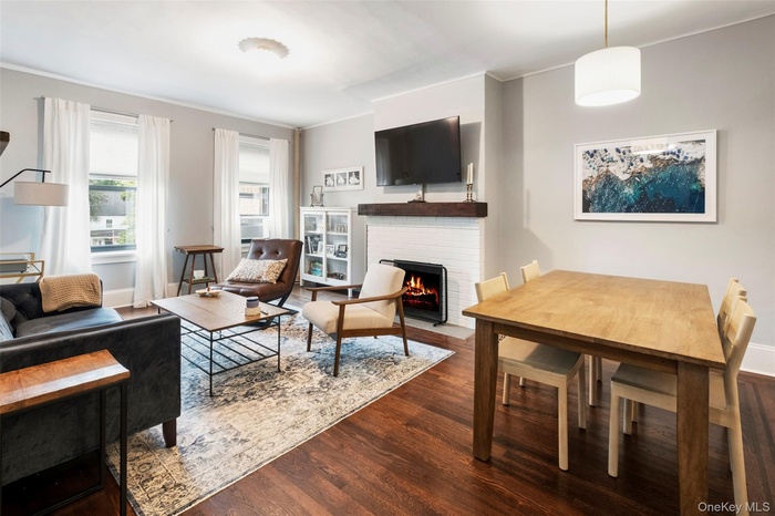 Living room featuring a fireplace, wood finished floors, and crown molding