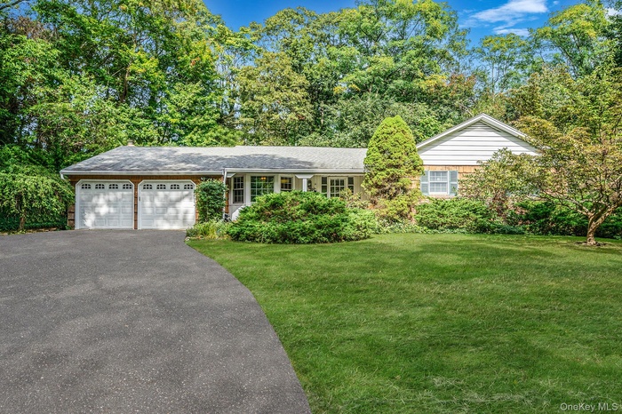 Single story home featuring a front lawn, asphalt driveway, and an attached garage