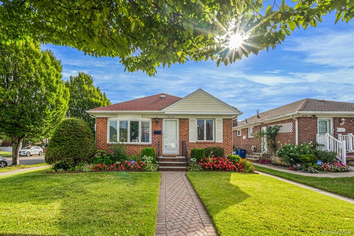 Bungalow-style home with a front yard and brick siding