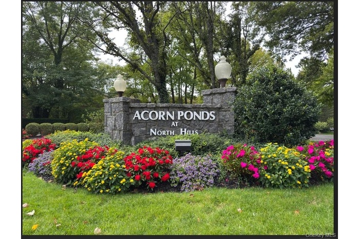 Community / neighborhood sign featuring a lawn