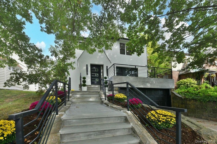 View of front facade with stucco siding and stairs