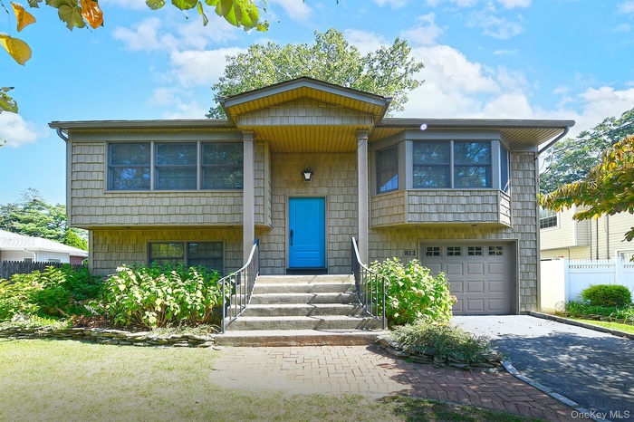 Bi-level home featuring a garage and driveway