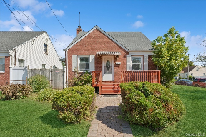 Bungalow-style home with brick siding, a chimney, and a shingled roof