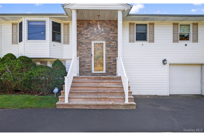 Bi-level home featuring an attached garage and driveway
