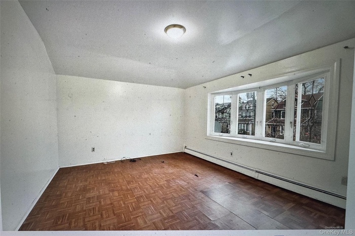 Unfurnished room with baseboard heating
