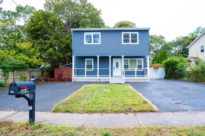 View of front of property featuring a porch and asphalt driveway