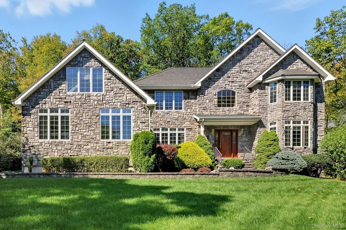 View of front of home featuring a front yard and stone siding