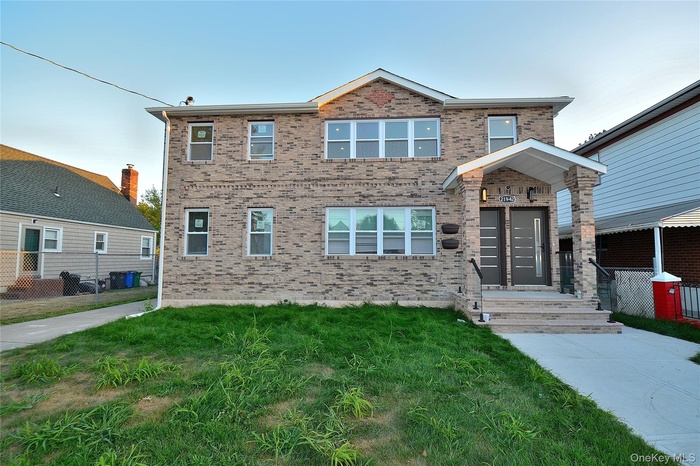 View of front of property with brick siding and a front lawn