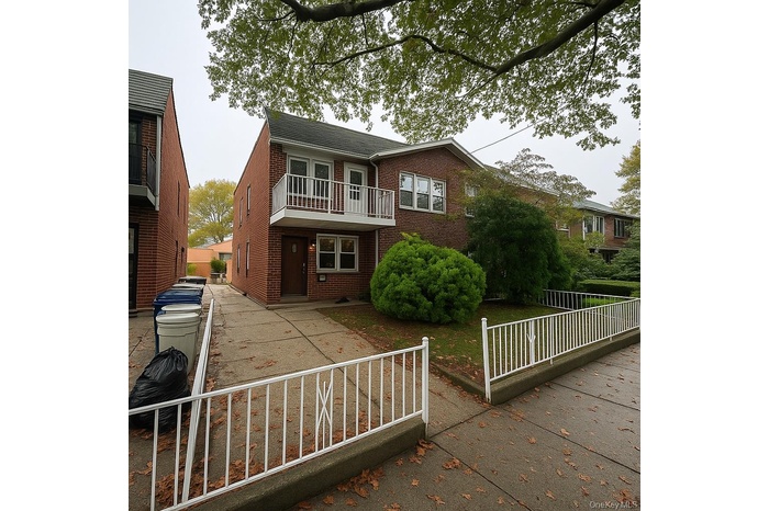 View of front of property with brick siding and a balcony